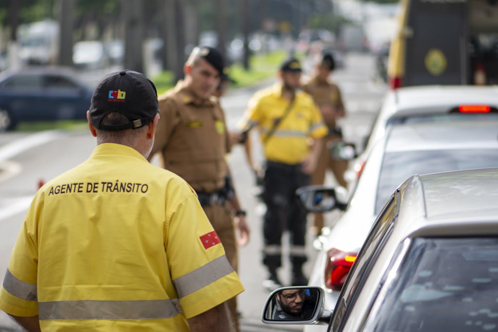 Traffic agent in bright uniform managing vehicles on a busy Londrina street.