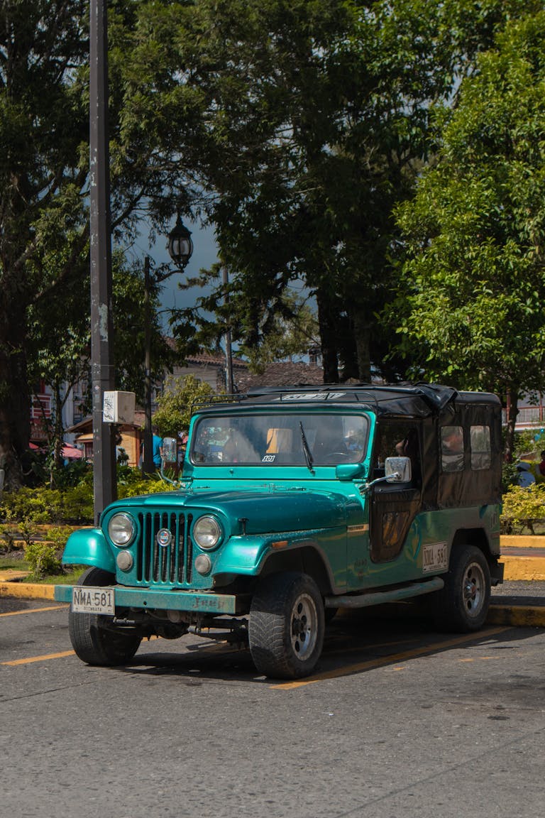 A classic teal jeep parked under the sun in Filandia, Quindío, Colombia.