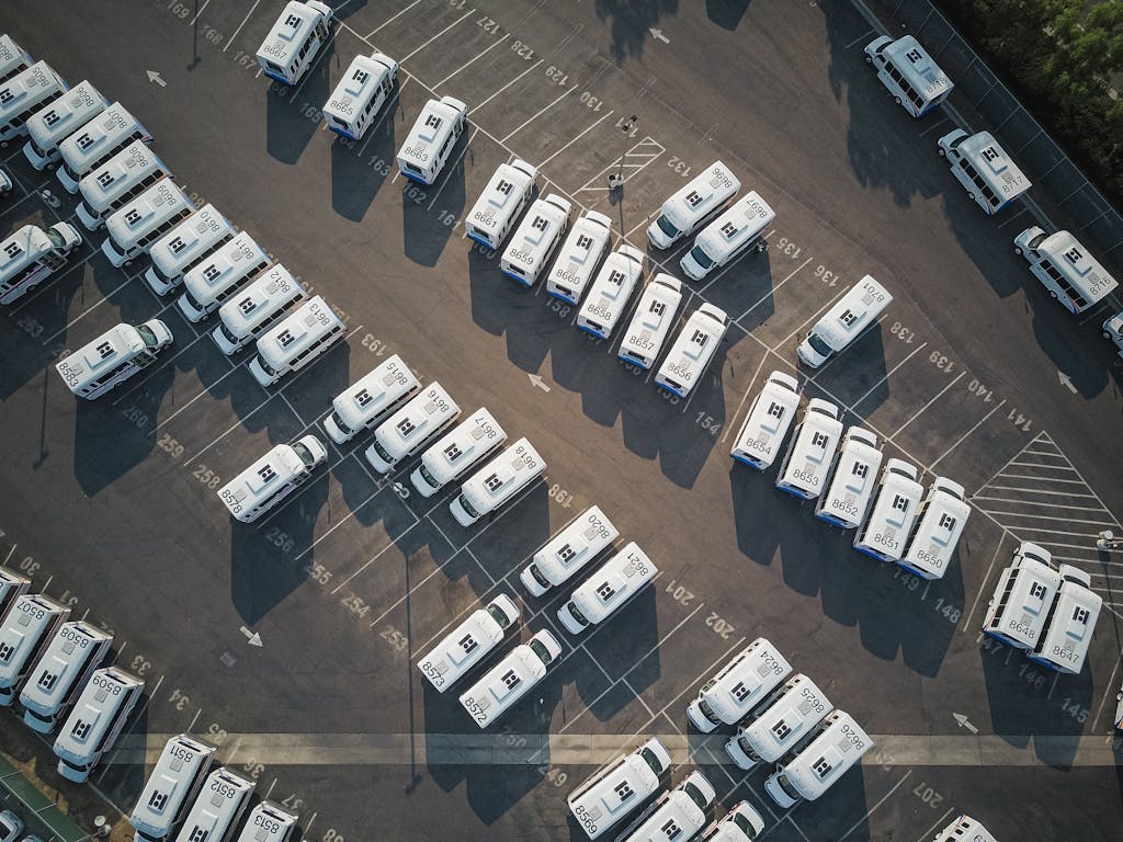 Imagen actual: Aerial drone shot of neatly organized vans in a large parking lot.