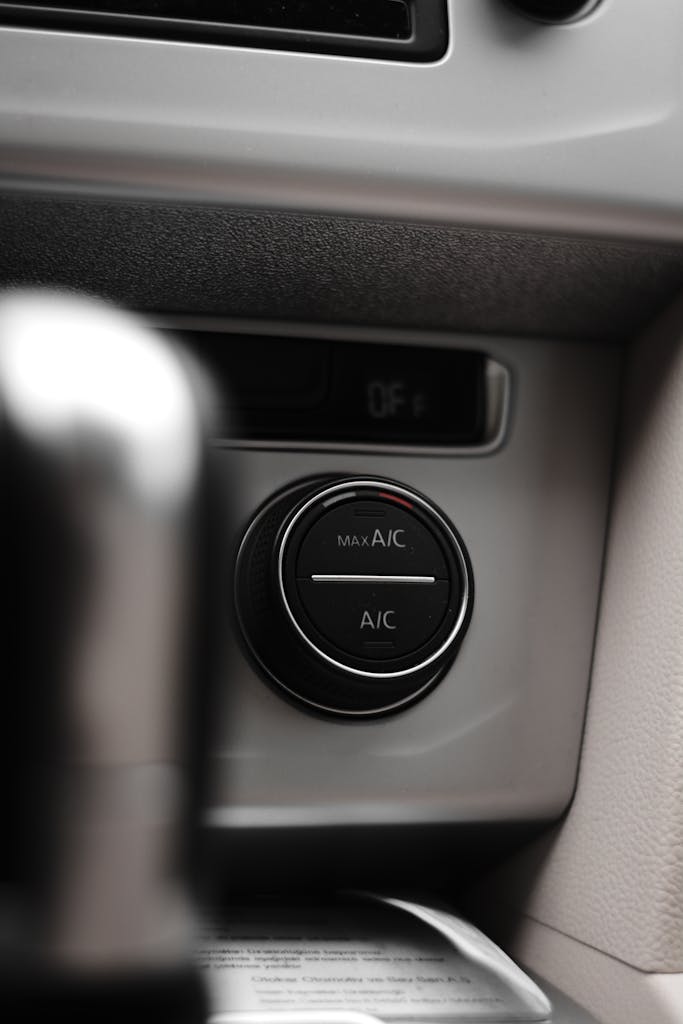 Imagen actual: Vertical close-up shot of a car air conditioning control dial, highlighting the dashboard interface.