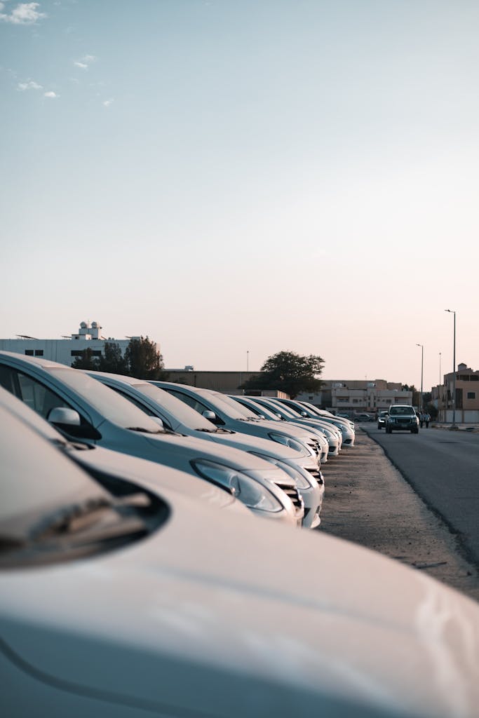 Imagen actual: Row of parked cars in a sunlit urban setting in Dammam, showing city life and transportation