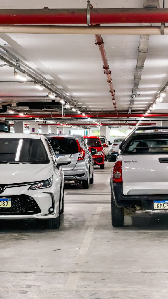 Imagen actual: A busy underground parking lot filled with various cars lined up in designated spots.