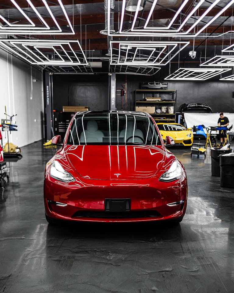 A luxury electric car parked indoors with striking LED lighting in a modern garage.
