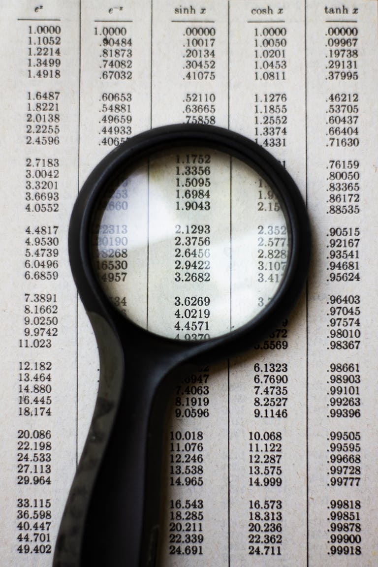 A magnifying glass highlighting mathematical data on a page, emphasizing numbers and calculations.