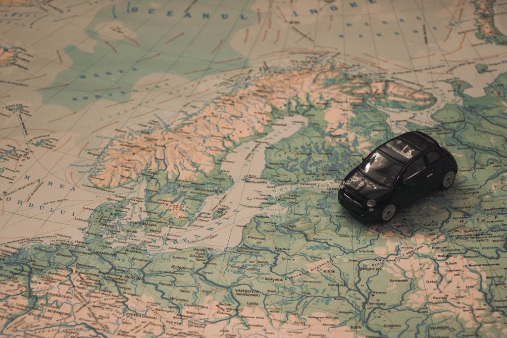 Imagen actual: A miniature black car on a detailed map of Scandinavia, symbolizing travel adventures.
