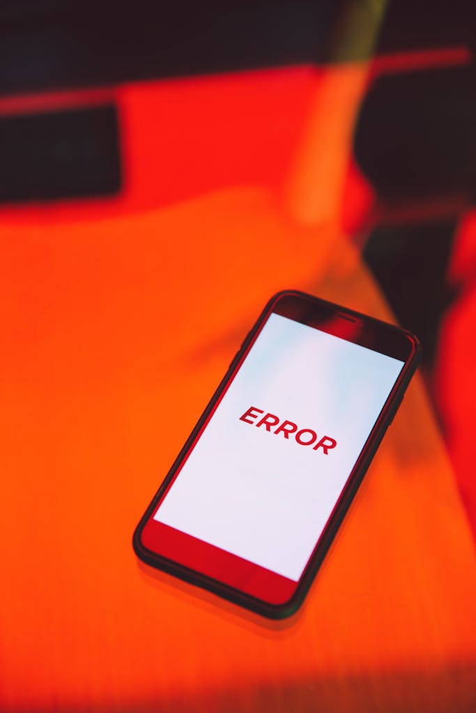 Imagen actual: Smartphone displaying an error message on a vibrant red surface.
