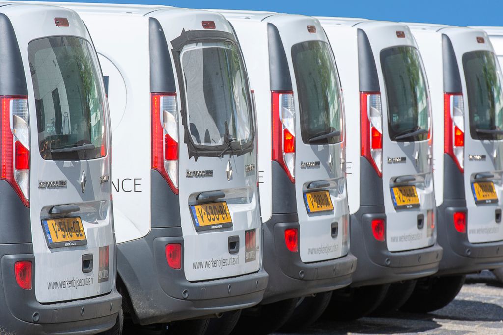 Imagen actual: A row of white delivery vans parked outdoors, showcasing uniformity and logistics.