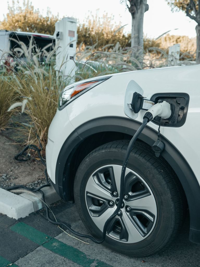 Imagen actual: Close-up of an electric vehicle charging at a station, promoting clean energy.